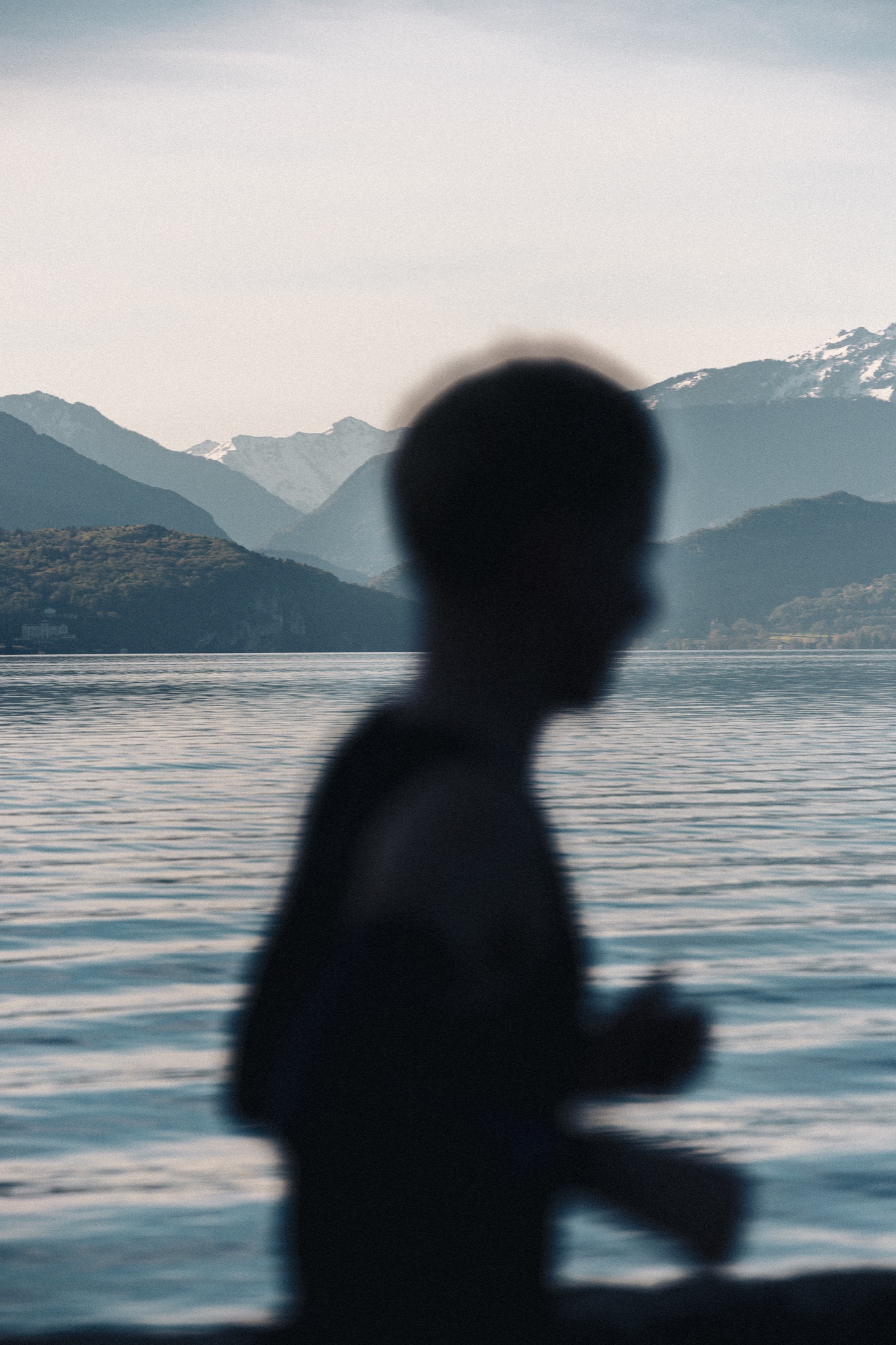 Silhouette d’un coureur devant le lac d’Annecy et les montagnes