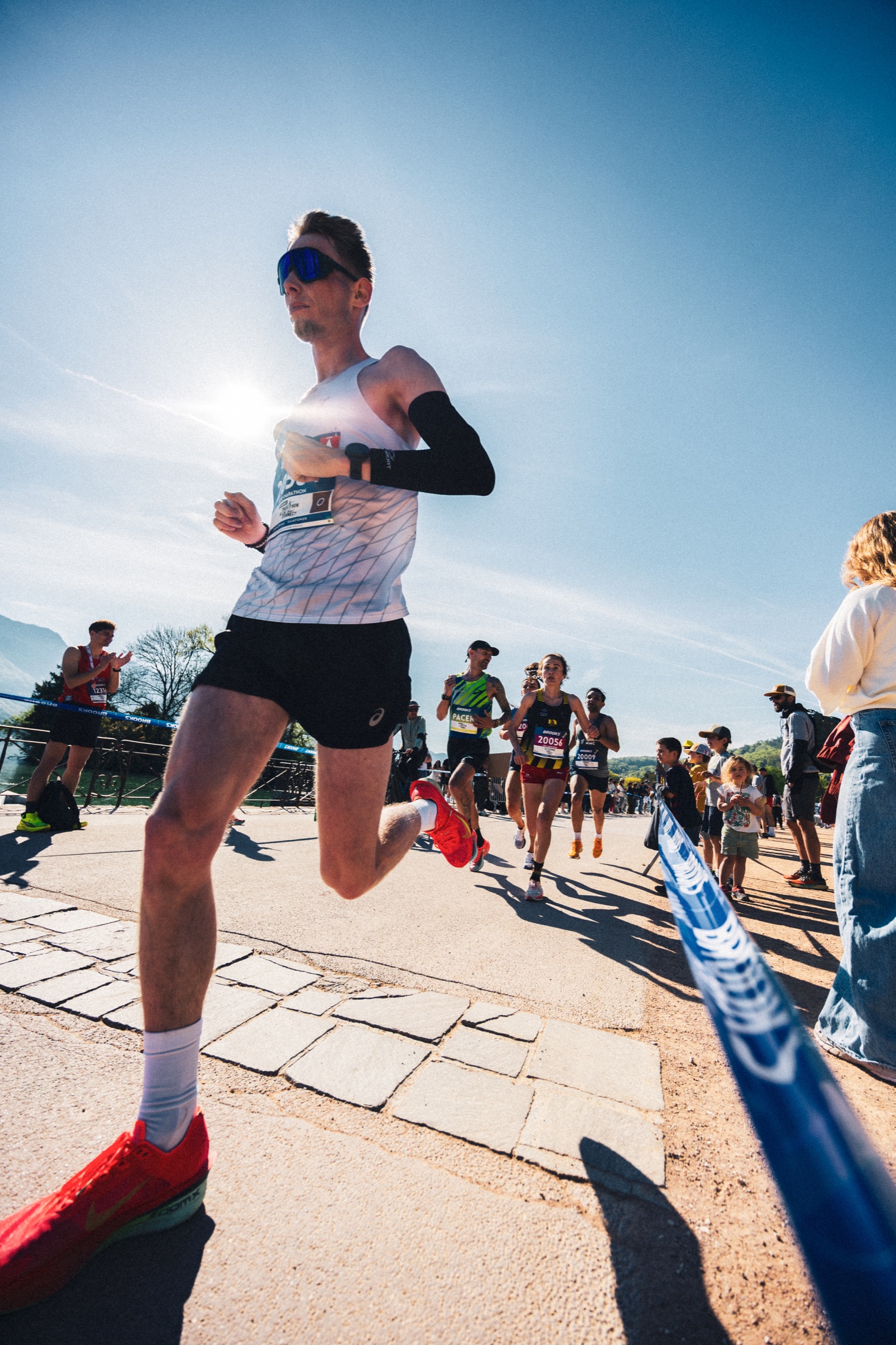Coureur passant au premier plan sur les quais du lac d’Annecy