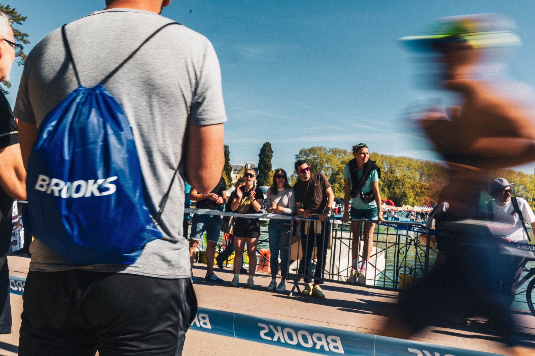 Coureur flou passant devant les spectateurs au bord du lac