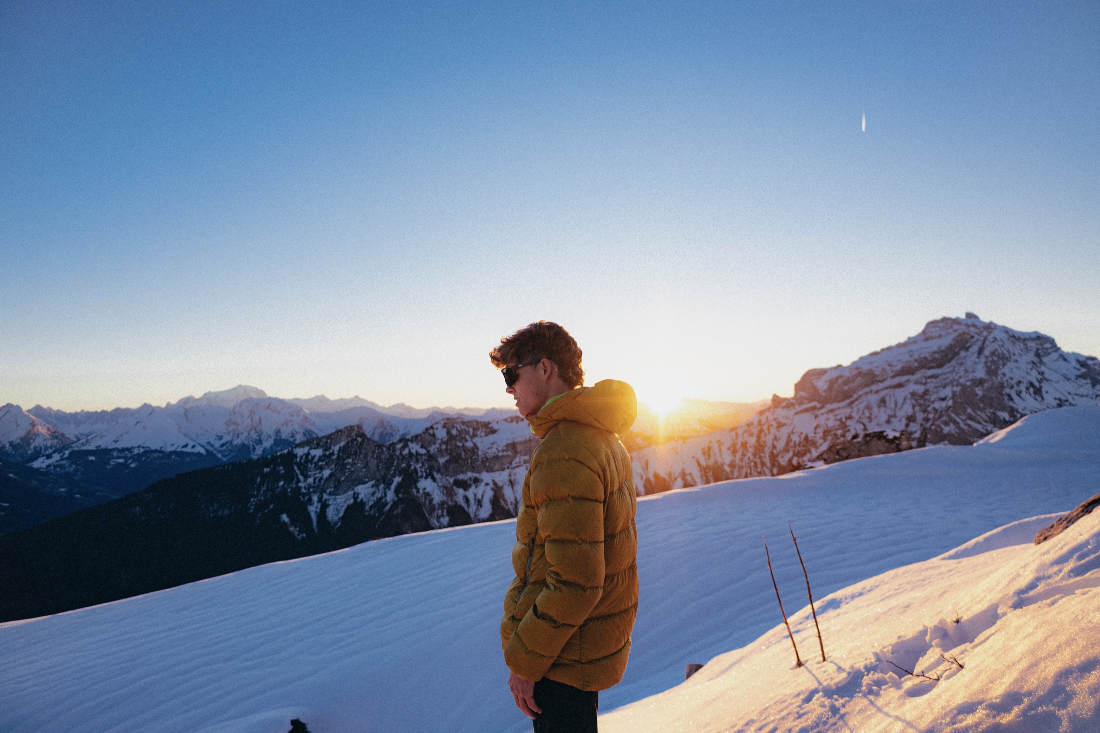 Josué Lobry face aux montagnes enneigées au lever du soleil