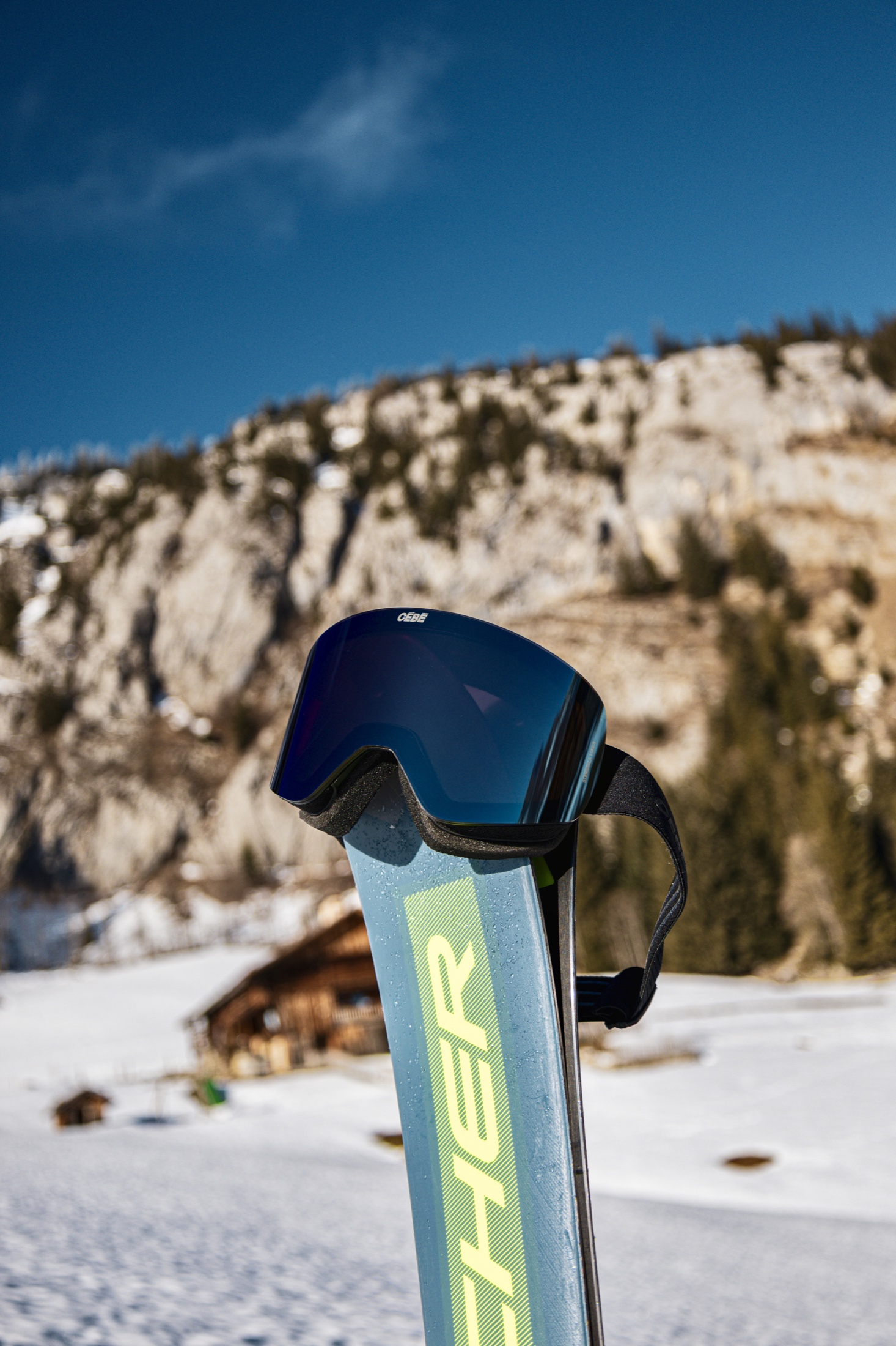 Masque Cébé posé sur une paire de skis face à la montagne