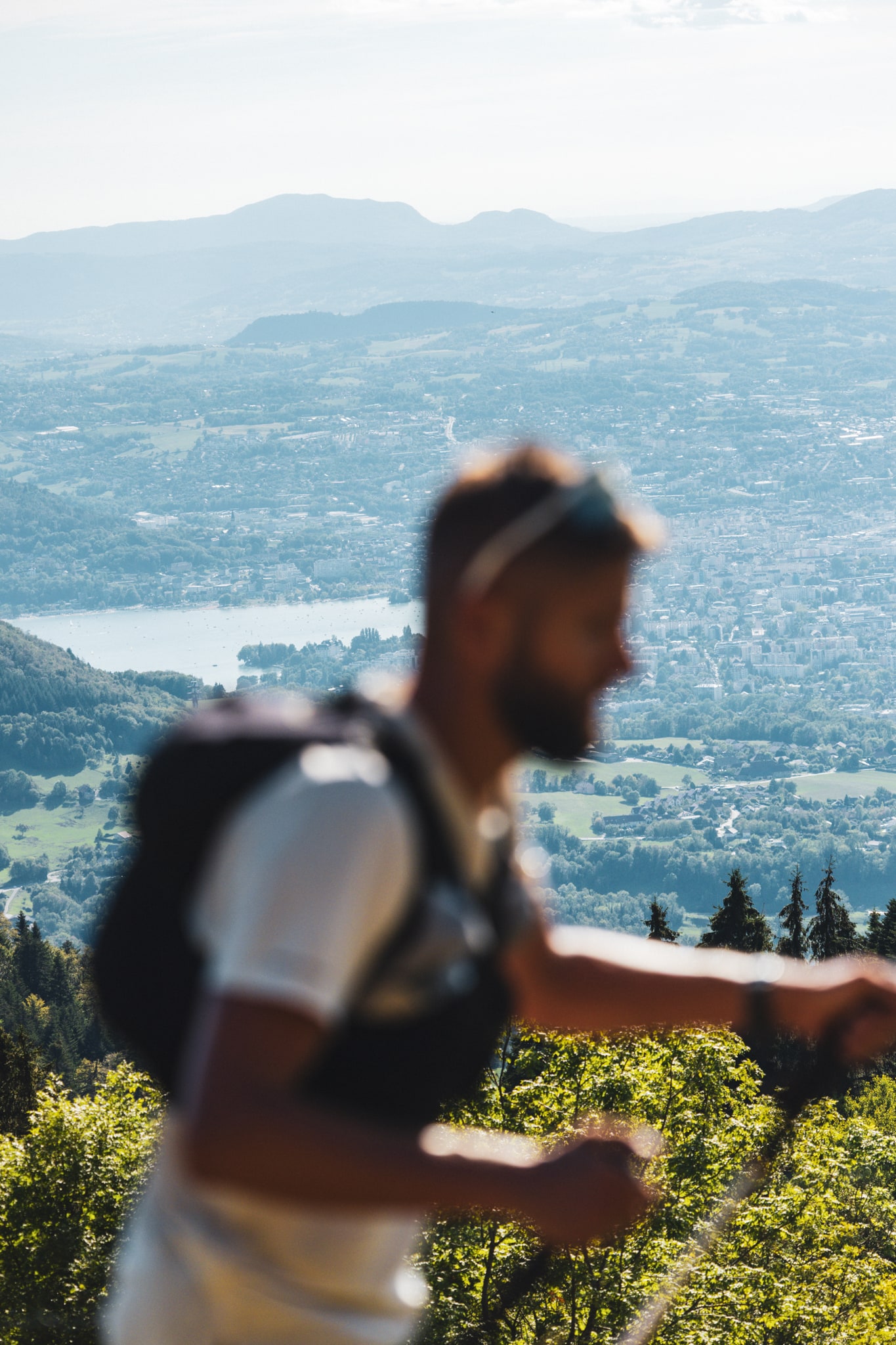 Un coureur au premier plan, avec Annecy et le lac en contrebas